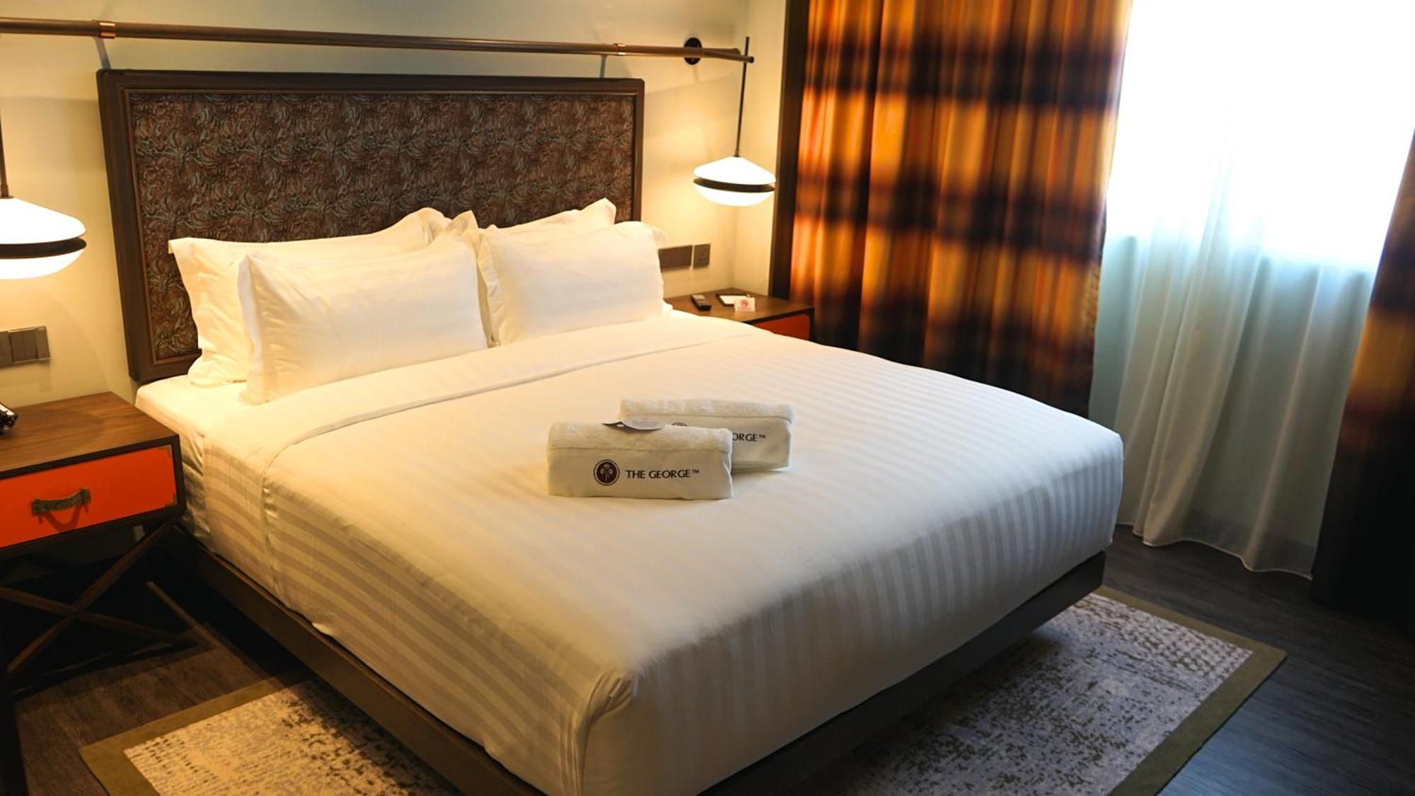 Отель The George Penang By The Crest Collection Джорджтаун Экстерьер фото A bed in a hotel room